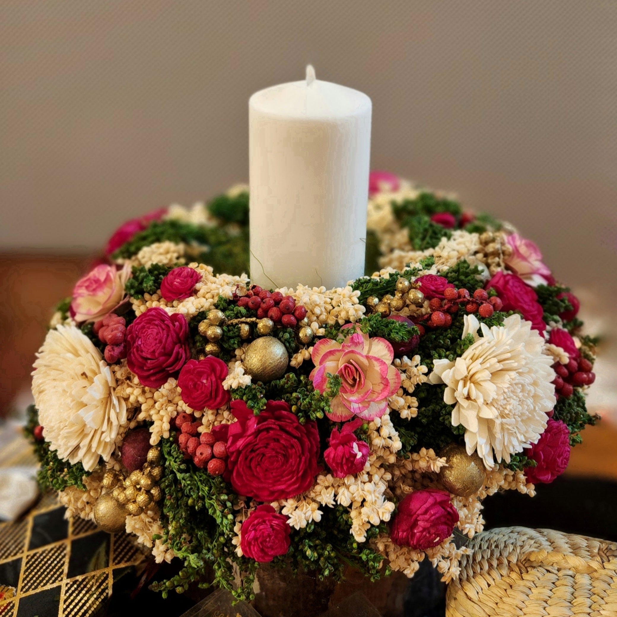 Decorative floral arrangement with a white candle on a table.