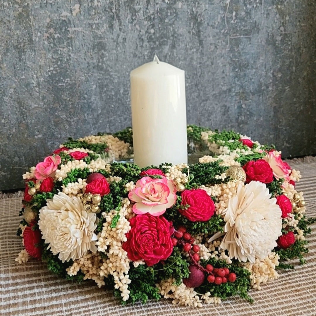 Decorative floral candle holder & centrepiece with a white pillar candle on a table