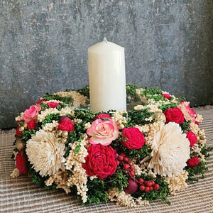 Decorative floral candle holder & centrepiece with a white pillar candle on a table